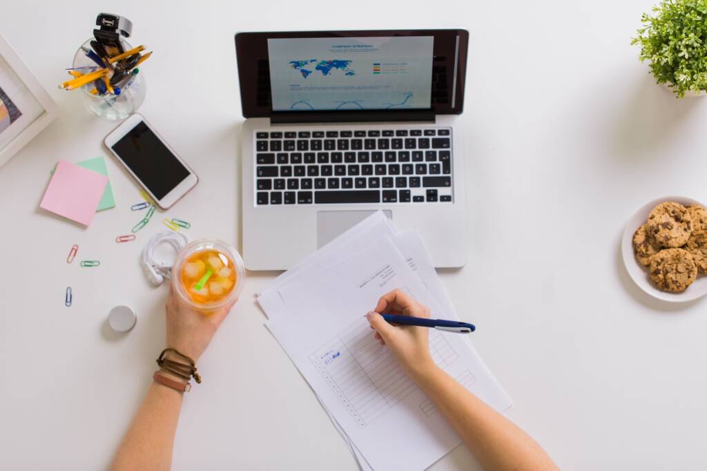 woman hands with papers and cup of drink at office